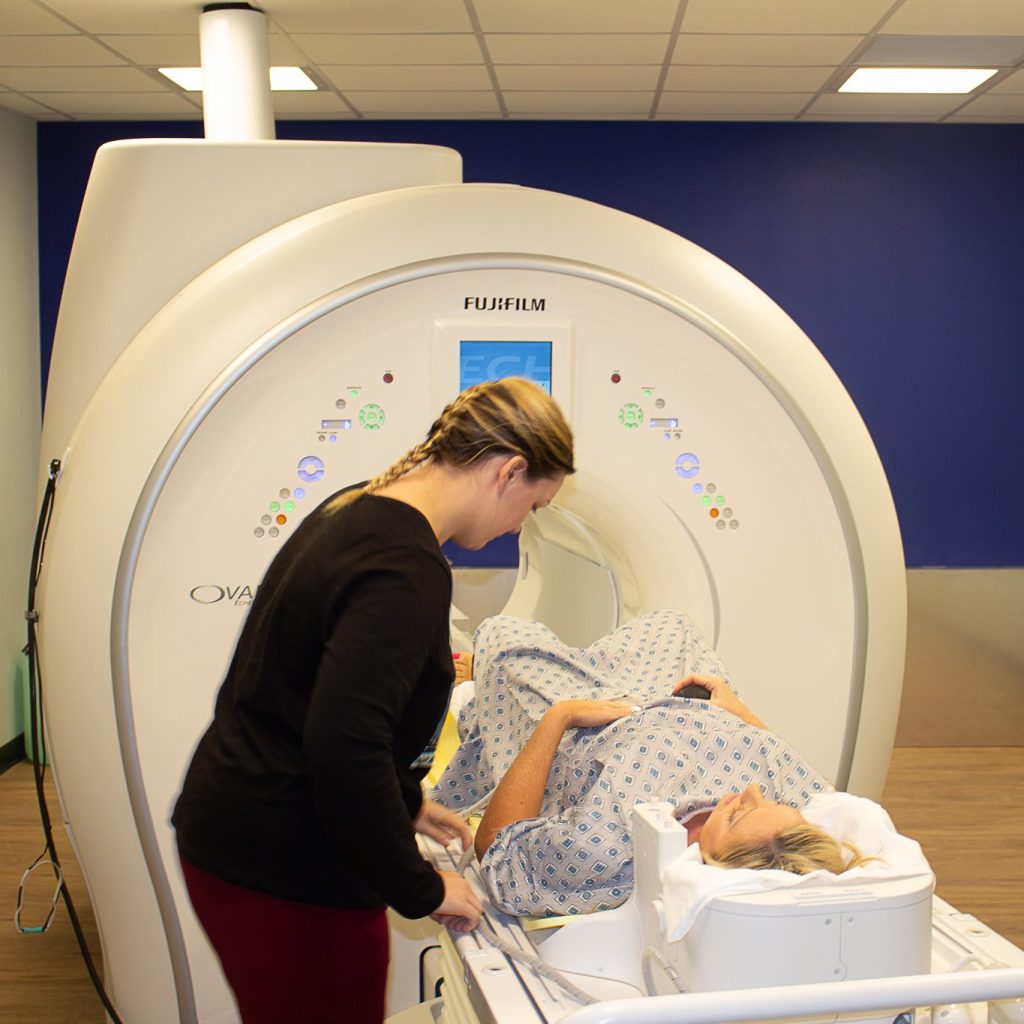 MRI Tech preparing a patient for their scan.