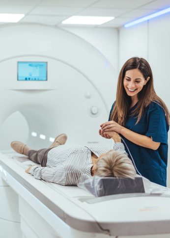 MRI Tech getting patient ready for a scan.